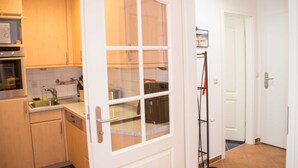A kitchen with wooden cabinets, a built-in oven, and a window with a view of the outside.