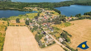 An aerial view of a lakeside village with houses, fields, and a large body of water. - Vacation apartment at Krebssee Whg. Otter - Otter (Heringsdorf)