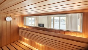 A wooden sauna with a large window, a clock, and a television. - Kapitänsbrücke - Penthouse (Kappeln)