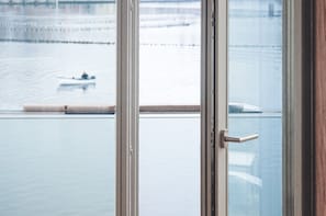 En vy genom ett fönster som visar en flod med en person som ror en båt.