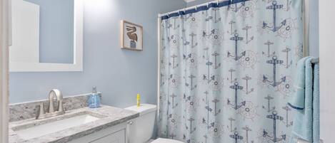 Un baño con lavamanos, espejo y retrete.