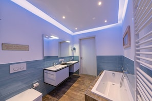 A modern bathroom with a double sink, a bathtub, and a mirror. - Lotsenhaus 11 (Kappeln)