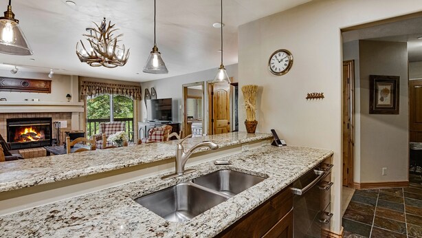 A kitchen with granite countertops, stainless steel sink, and pendant lighting. - Ski OR Walk to Lifts, Village and Hot Tub! Luxurious & Clean Beaver Creek Condo (Beaver Creek)