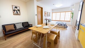 A compact living space with a dining table, a sofa, and a bed. - TORA HOTEL Taito D (Tokyo)