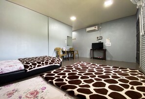 A room with two beds, a desk, a chair, a television, and an air conditioning unit. - Hotel O Kampung Stay Kilimu (Ranau)