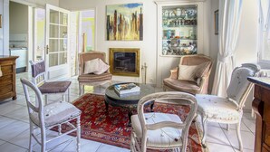 A spacious living room with a round coffee table, several antique chairs, a red patterned rug, and a glass cabinet with decorative items. - Maison 350 m Centre, Chambres Calmes, Spacieuses (Angoulême)