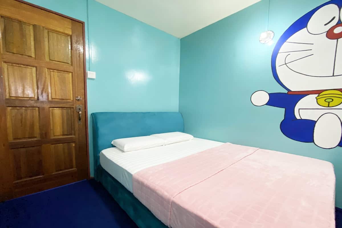 Un dormitorio con una cama individual, una puerta de madera y un mural en la pared.