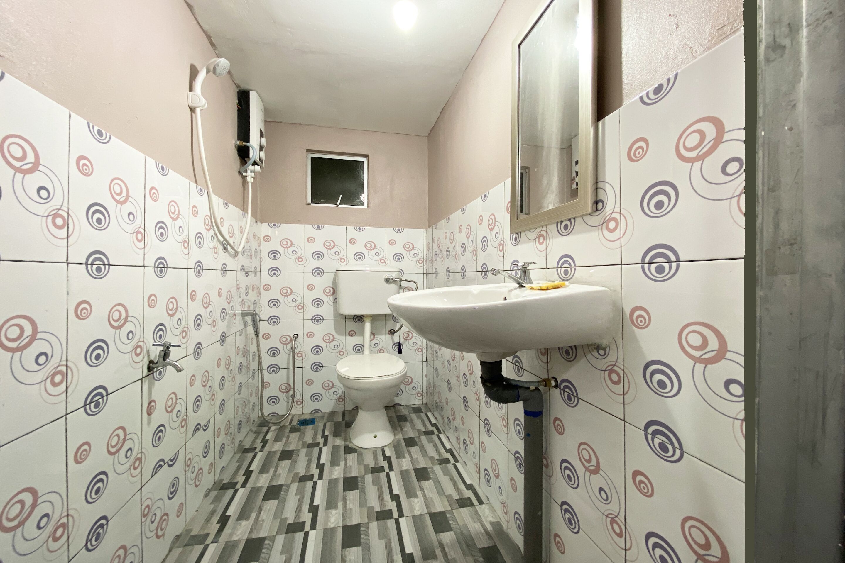 Une salle de bain avec des toilettes, un lavabo et une douche.