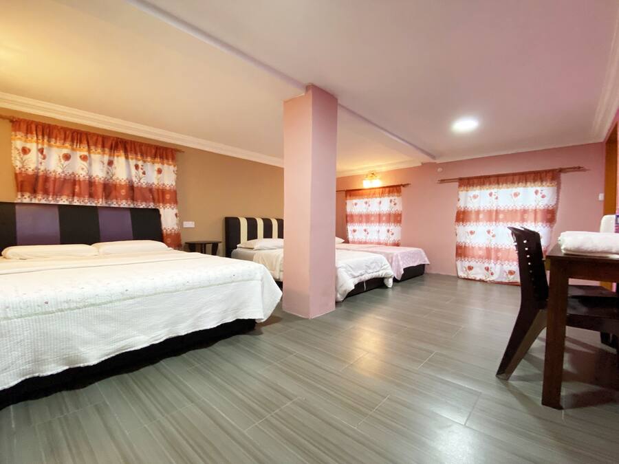 A hotel room with two beds, a wooden chair, and a small table.