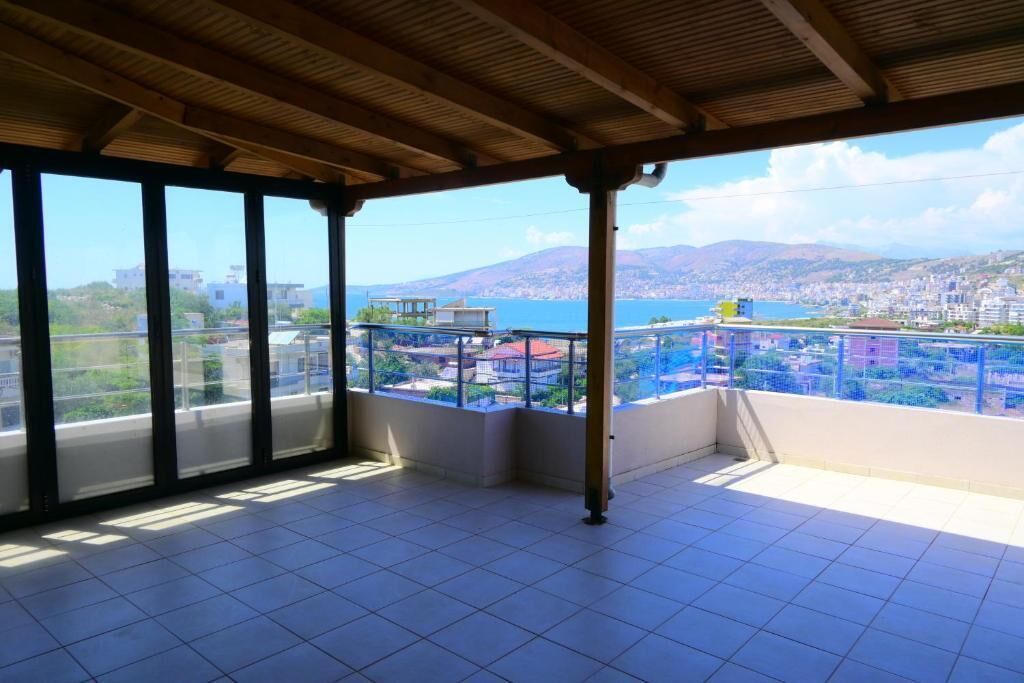A balcony with a view of a city and mountains.