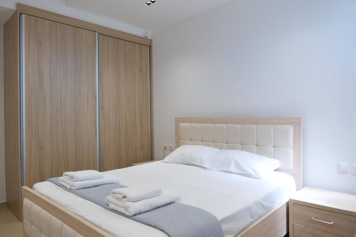 Een slaapkamer met een bed, nachtkastje en een kledingkast.