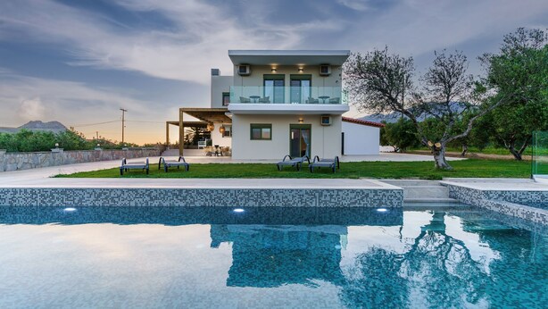 Una casa moderna de dos pisos con piscina delantera.