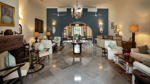 Un vaste salon doté d’un haut plafond, de lustres et de ventilateurs de plafond.