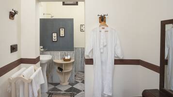 Un baño con lavamanos, espejo y perchero para toallas.