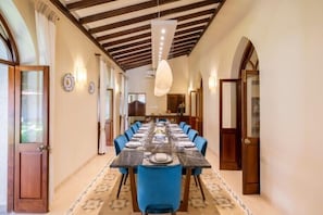 Enjoy meals in this inviting dining area with a long table and comfortable blue chairs.