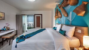 Une chambre d’hôtel avec un grand lit, un bureau, une vue sur la ville et des paniers décoratifs en osier accrochés au mur.