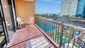 A balcony with a view of a swimming pool and a building. - Newly Remodeled Caravelle-Studio, Views with Pools (Myrtle Beach)
