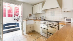 A kitchen with white cabinets, a stove, and a sink.