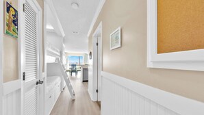 A hallway with a bunk bed, a desk, and a chair. - ☀️Beach Front-Pool + HotTub-Latitude 29 #2☀️ (Panama City Beach)