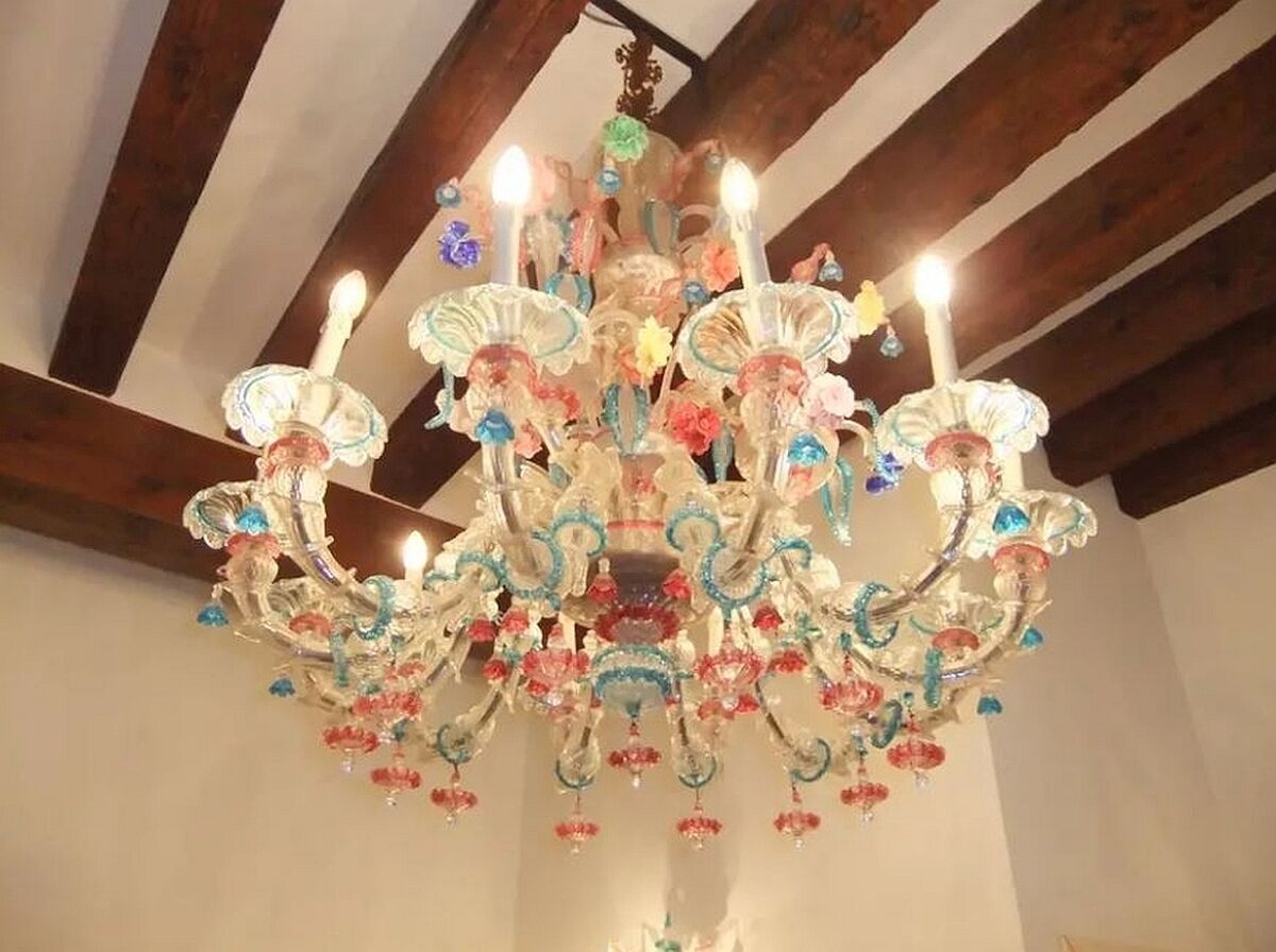 Un lustre à plusieurs bras, orné de décorations suspendues.