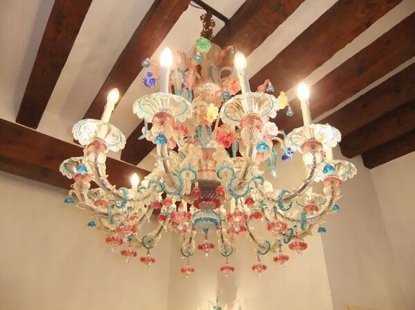A chandelier with multiple arms and hanging decorations. - Signorile su Corte Veneziana (Venezia)