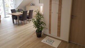 A modern interior with a dining area, a potted plant, and a wooden door. - Vacation home MoselCharme "Burgblick" (Alken)