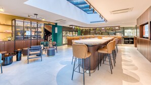 Een modern interieur met een bar in het midden, zitgedeeltes en een dakraam.
