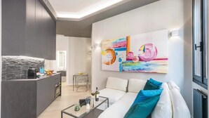 Una sala de estar moderna con un sofá, una mesa de centro y una obra de arte en la pared.