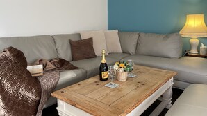 A living room with a grey sofa, a wooden coffee table, and a lamp. - One bedroom balcony apartment with allocated parking close to Gunwharf Quays (Portsmouth)