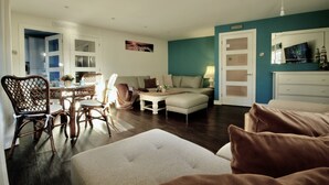 A living room with a dining area, a sofa, a coffee table, and a TV. - One bedroom balcony apartment with allocated parking close to Gunwharf Quays (Portsmouth)