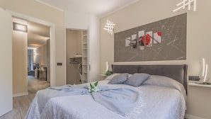 Een moderne slaapkamer met een groot bed, een nachtkastje en een kunstwerk aan de muur.
