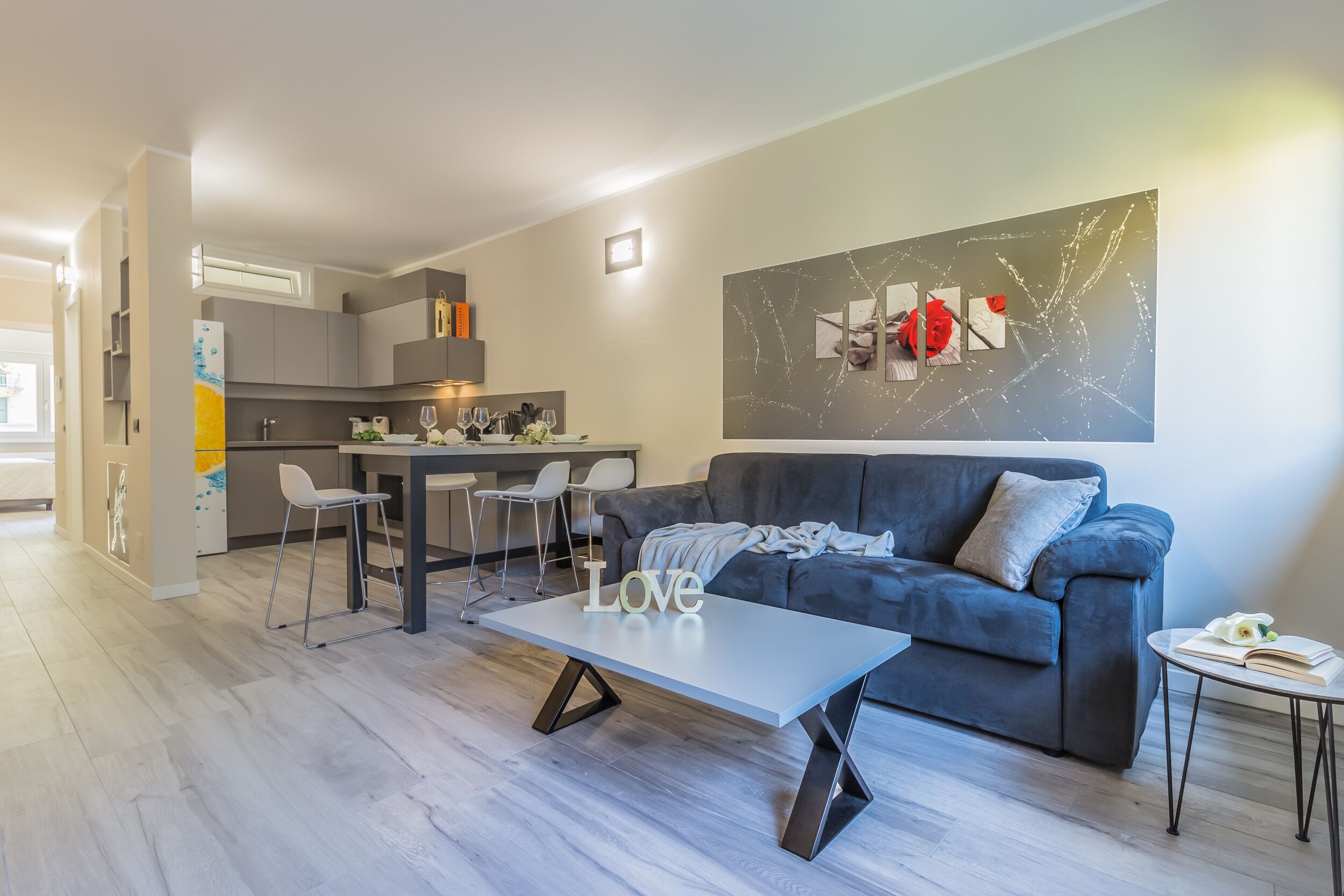 Un soggiorno moderno con un divano grigio, un tavolino da caffè e una zona pranzo con sedie.