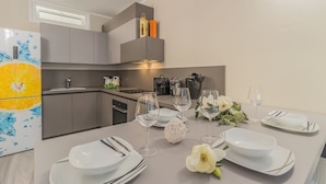 Een moderne keuken met grijze kastjes, een inbouwoven en een koelkast met een citrusprint.