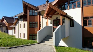 A modern multi-story building with a prominent staircase leading to the entrance.