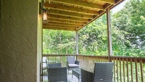 A covered outdoor area with wicker furniture and a patterned floor. - THE DOGWOOD @ DOLLYS DRIVE * Wifi Grill Woods Mtns (Sevierville)