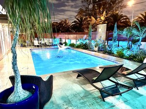 Une piscine avec des chaises longues et une clôture en bois.