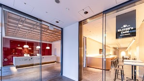 A modern interior with a reception desk, seating area, and a café sign. - The Kanzashi Tokyo Asakusa (Tokyo)