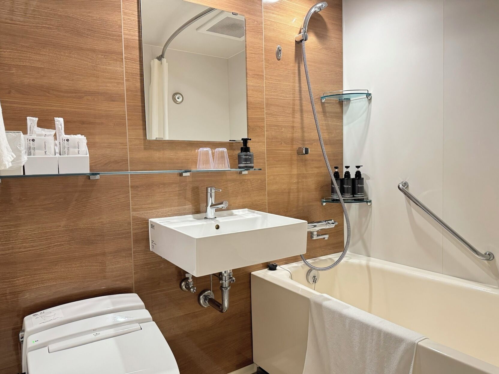 A modern bathroom with a white sink, a glass shower enclosure, and a bathtub.
