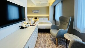 A modern hotel room with a flat-screen TV, a bed with white linens, a gray armchair, and a small wooden table. - The Kanzashi Tokyo Asakusa (Tokyo)