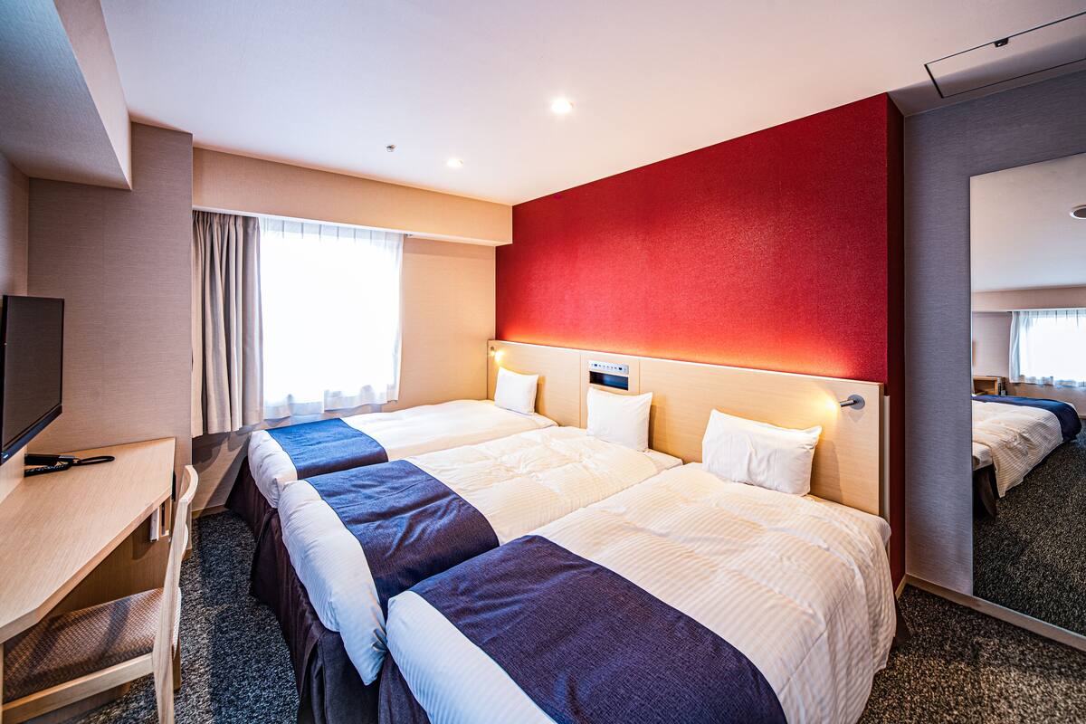Een hotelkamer met een groot bed, een bureau en een televisie.