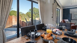 A dining table set for breakfast with croissants, a glass of orange juice, and various dishes.
