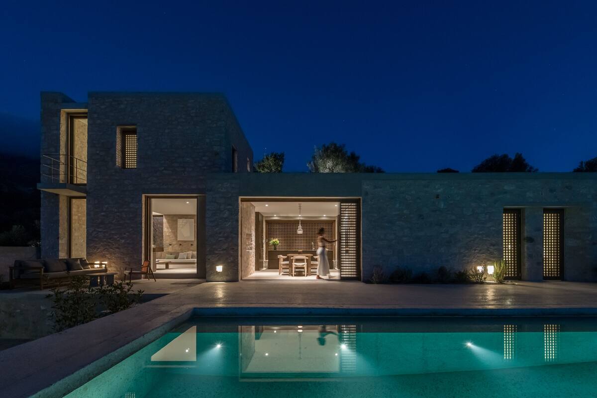 Ein modernes Haus mit Pool, großen Fenstern und einem hellen Innenraum.