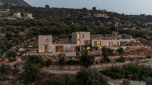 A modern villa with a stone facade, multiple rooms, and outdoor seating areas. - Monolithoi Villas Mani (West Mani)