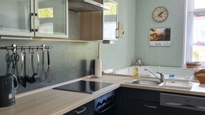 Une cuisine moderne avec un plan de travail en bois, des armoires noires, un four encastré et une fenêtre offrant une belle vue.