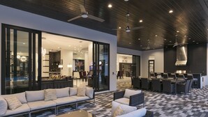 A spacious outdoor area with a modern patio, seating arrangements, and a kitchen area. - Royale Reunion | 10BR Luxe Estate w/ Huge Private Pool, Casino + Arcade, and Theater Near Disney (Kissimmee)