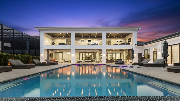 Un bâtiment moderne à deux étages avec une piscine devant.