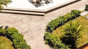 A swimming pool with lounge chairs and umbrellas, surrounded by greenery and buildings. - Khai Hotel Bodrum (Bodrum)