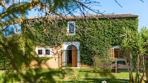 Une maison avec un jardin, une porte en bois et une fenêtre.