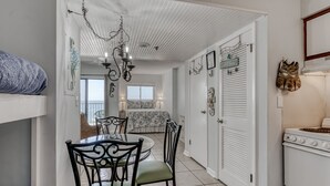 Ein kompakter Wohnraum mit Essbereich, Küchenzeile und Schlafzimmer mit Balkon.