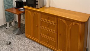 Une petite cuisine équipée d’un four à micro-ondes, d’un grille-pain et d’une machine à café, le tout installé sur un plan de travail en bois.